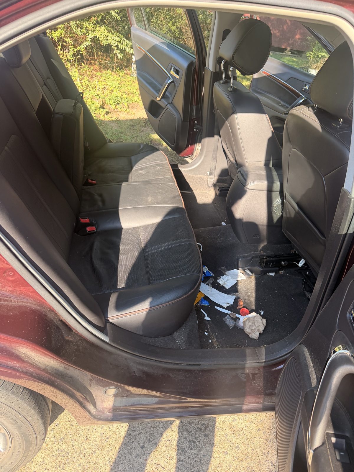 Lincoln sedan back seat with trash on the floor before detailing